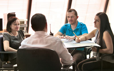 Foto de 4 personas reunidas tomando desiciones